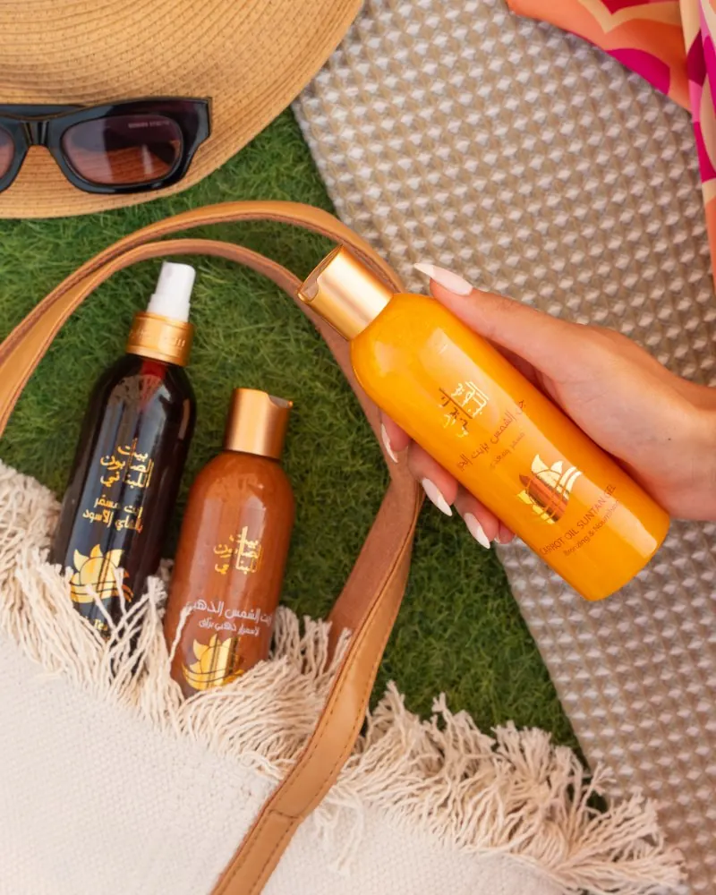 Bait Al Sabon skincare bottles on a summer picnic blanket